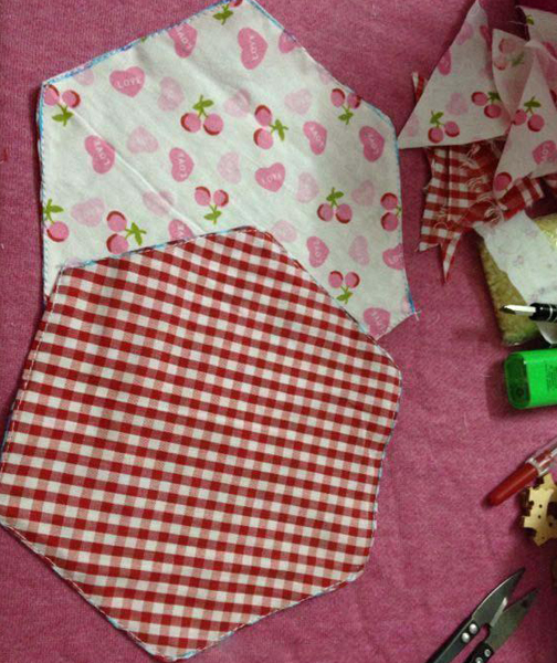 步骤一：把准备好的棉布剪成一个正六边形，为了显现清新甜美的气质，这里用的是小碎花棉布和格子棉布，总共剪四块。
